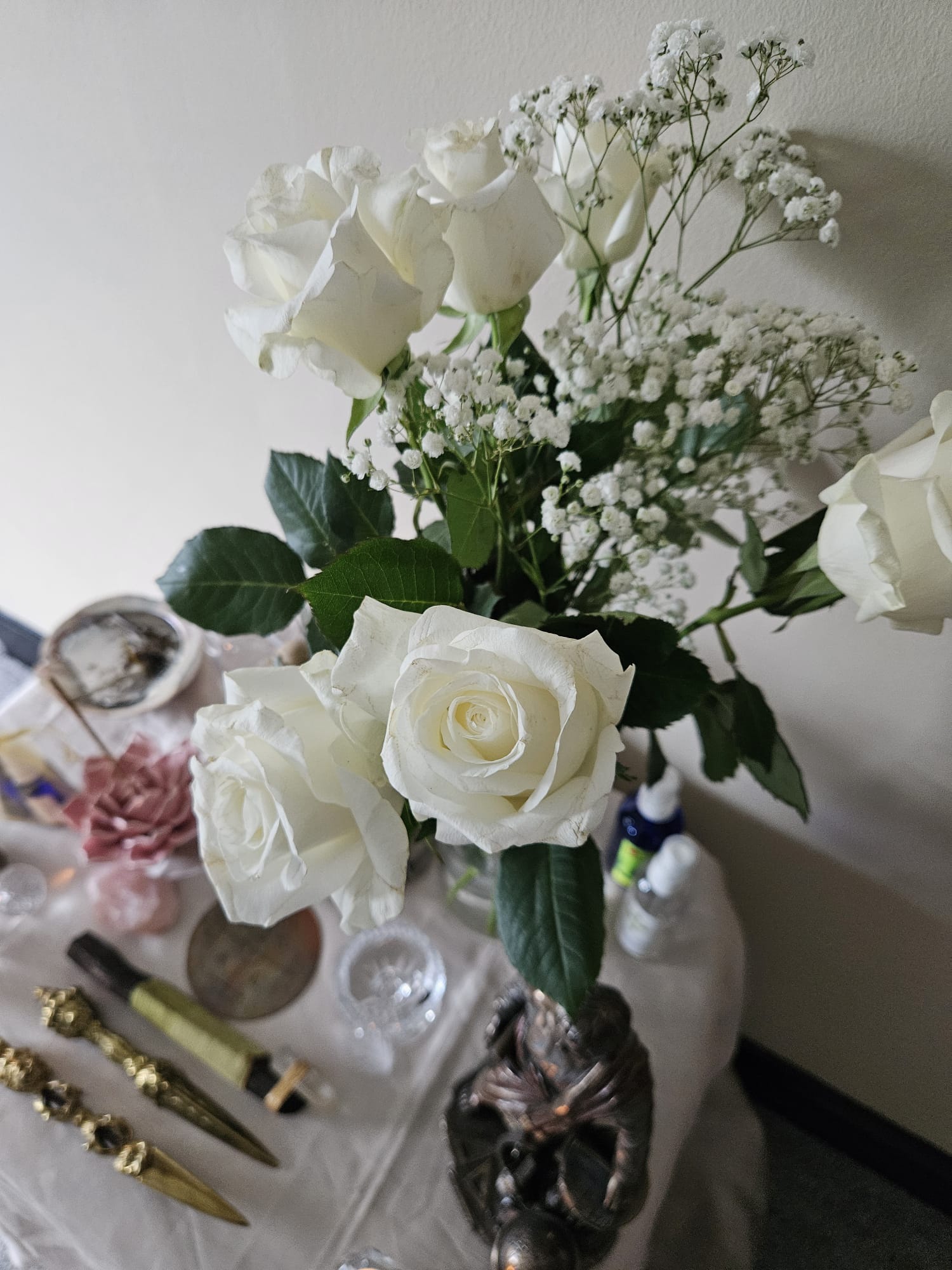 White roses and ritual tools on the altar in the workshop space
